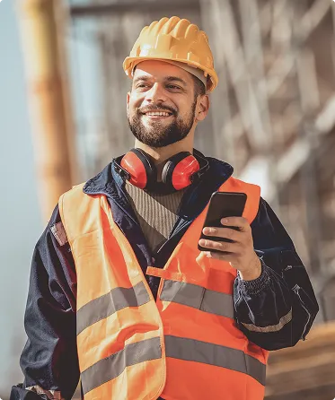 BauKarriere-Mitarbeiter mit Warnweste am Telefon auf der Baustelle